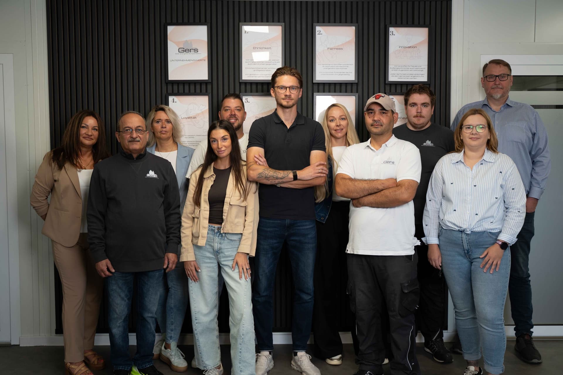 Das gesamte Team von Gers Erneuerbare Energien vor der Wertewand in Geeste